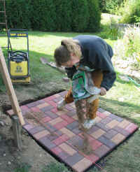 Cathy spreads sand on the patio